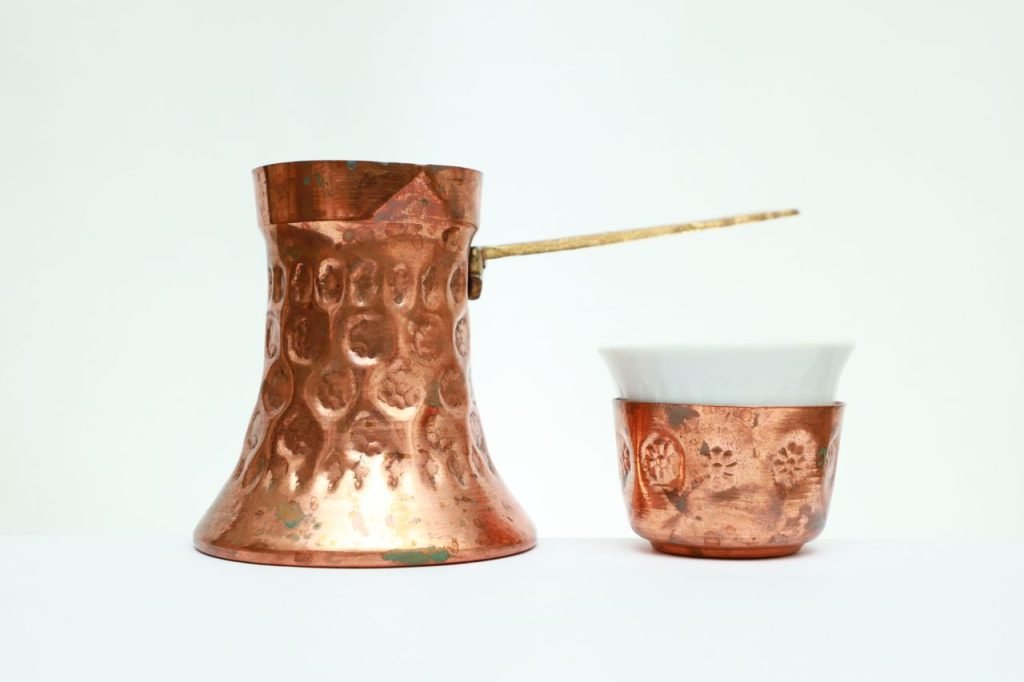 Demo Post 3 Still life of a copper Turkish coffeepot and cup on a white background.